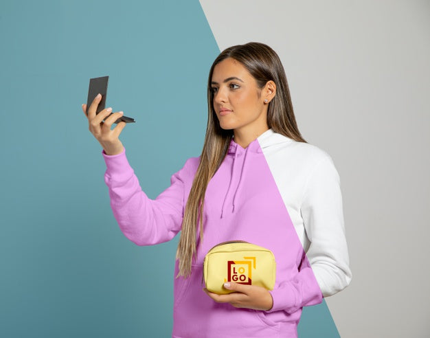 Free Front View Of Woman In Hoodie Holding Make-Up Pouch And Looking In The Mirror Psd