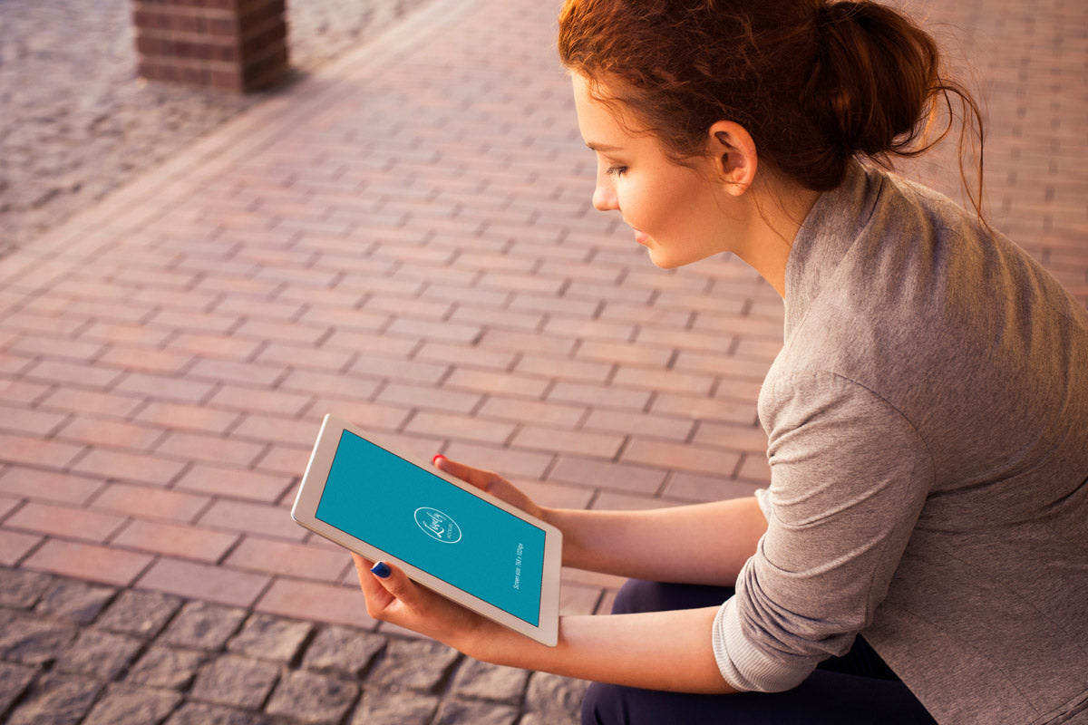 Free Woman Holding or Watching an iPad Mockup