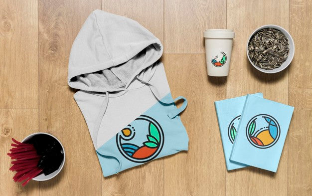 Free Top View Folded Hoodie Mock-Up With Notebooks And Sunflower Seeds Psd
