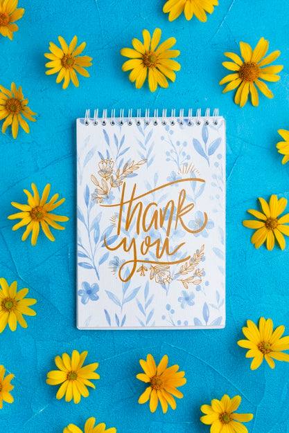 Free Top View Of Notebook And Flowers On Blue Background Psd