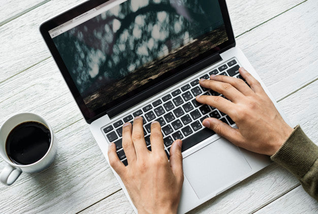 Free Aerial View Of A Man Using Computer Laptop On Wooden Table Psd