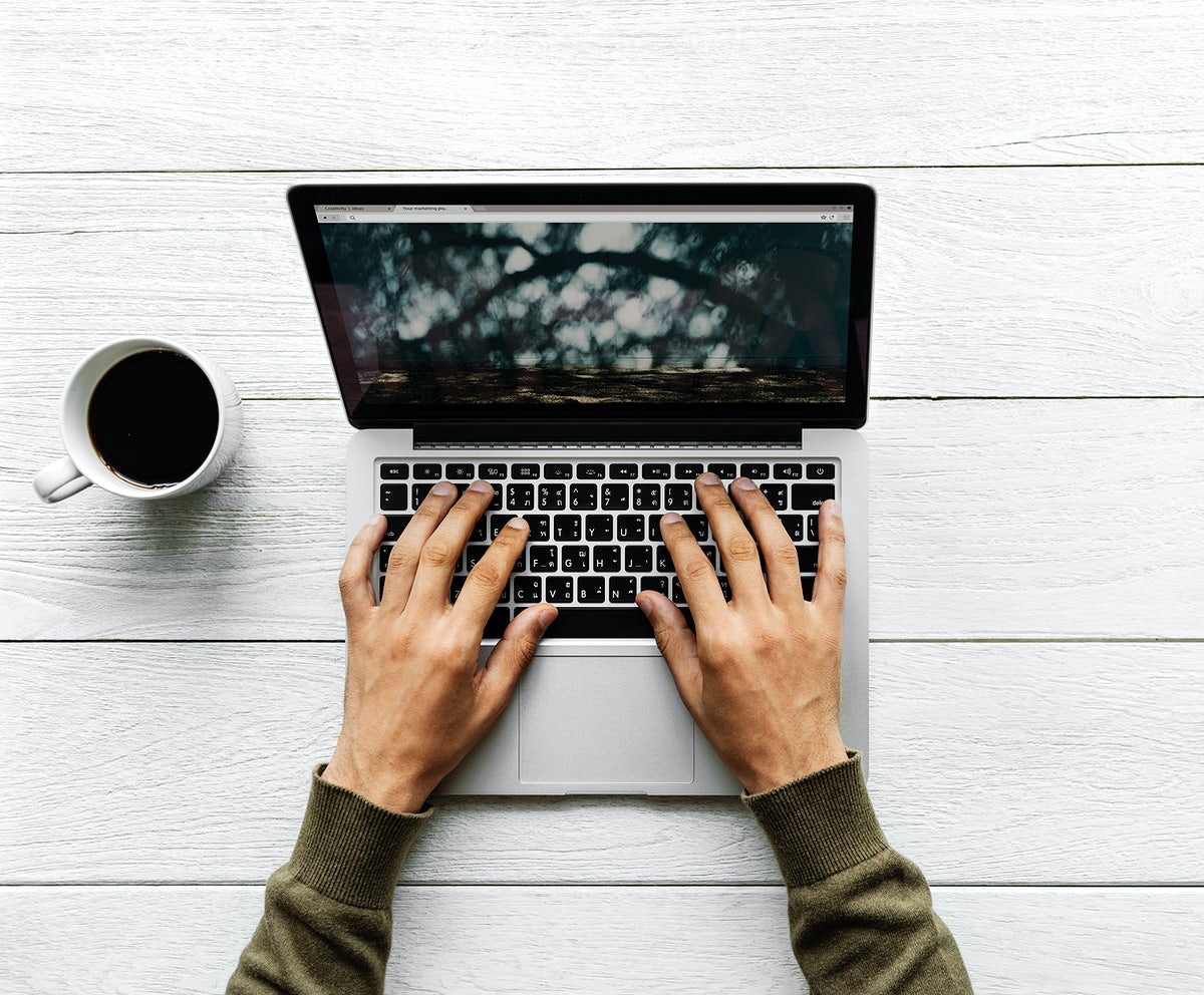 Free Aerial View Of Man Using A Computer Laptop On Wooden Table Workspace Concept