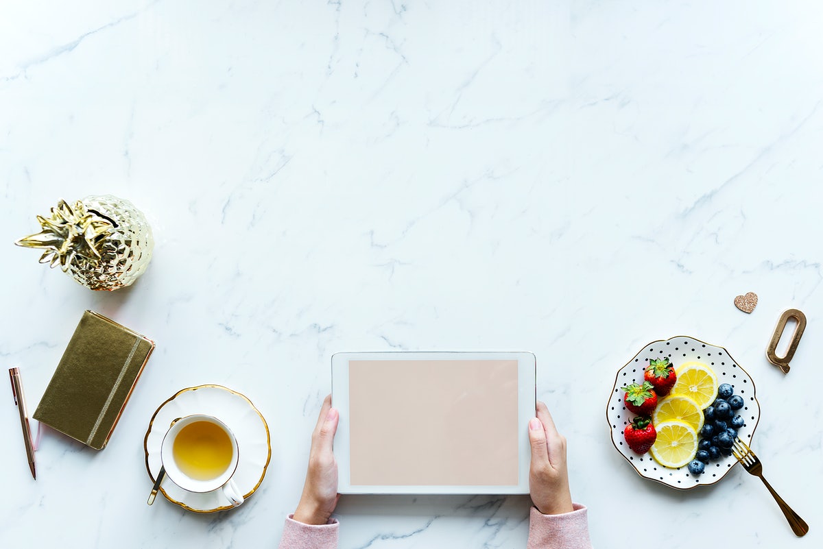 Free Aerial View Of Woman Using A Digital Tablet On A Marble Table With Design Space