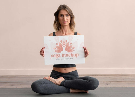 Free Athletic Young Woman Holding Mock-Up Banner While Doing Yoga Psd