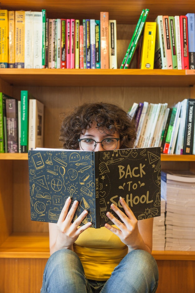 Free Back To School Concept With Girl Reading Book In Library Psd