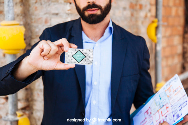 Free Businessman Showing Business Card In Front Of Construction Site Psd