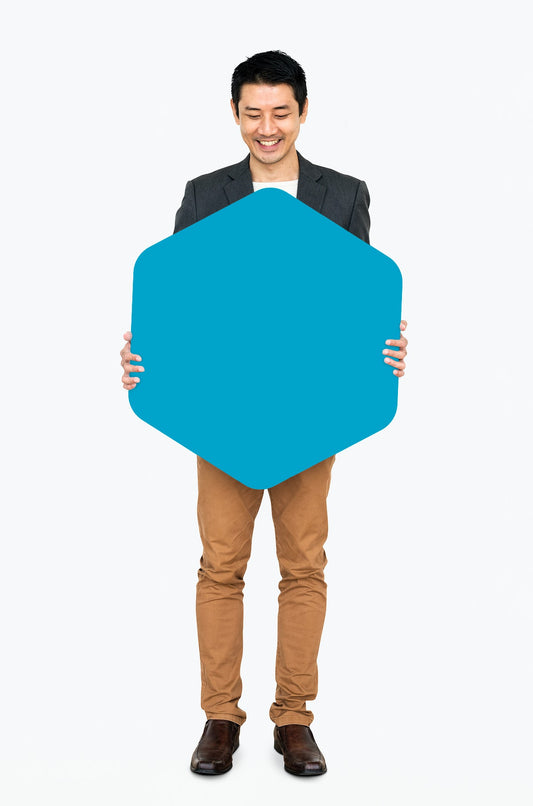 Free Cheerful Man Showing A Blank Blue Hexagon Shaped Board