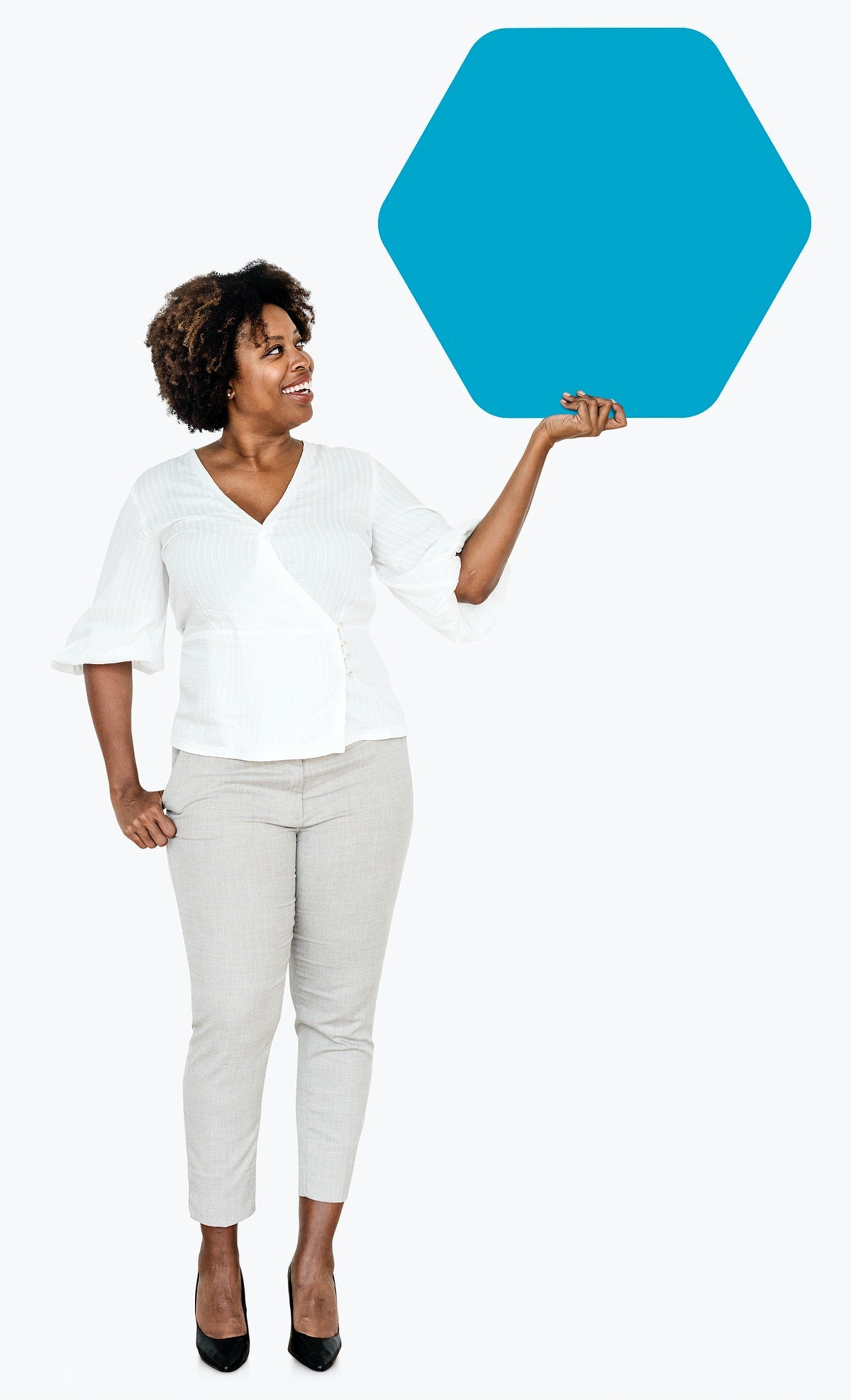 Free Cheerful Woman Showing A Blank Blue Hexagon Shaped Board