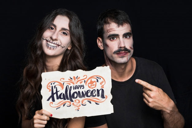 Free Couple Holding Paper With Halloween Lettering Psd