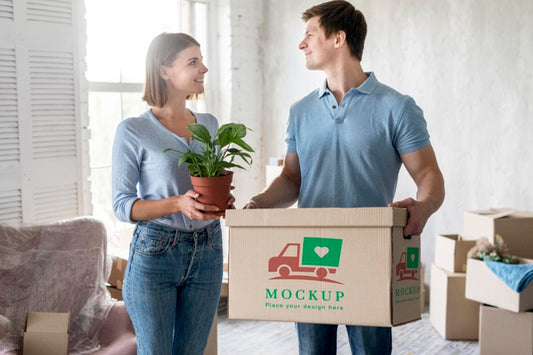 Free Couple Holding Plants And Box With Objects For Their New Home Psd
