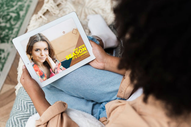 Free Female Sitting On Couch With Tablet In Her Hand Over The Shoulder Shot Psd