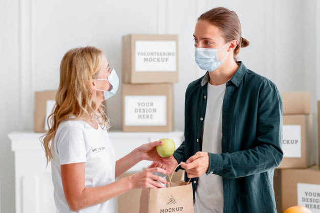 Free Female Volunteer With Medical Mask Handing Out Food Donation To Man Psd