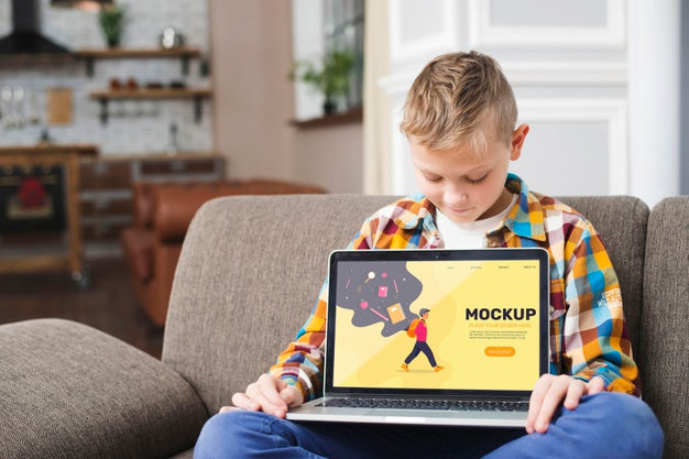 Free Front View Of Kid On Couch Holding Laptop Psd