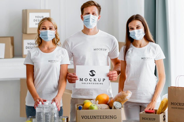 Free Front View Of Volunteers With Medical Masks Holding Blank Paper Next To Food Box Psd