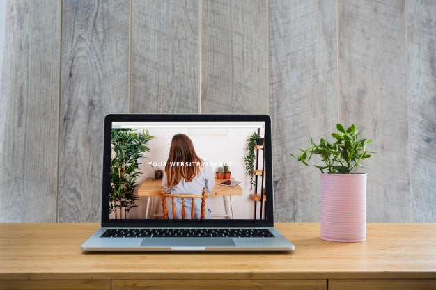 Free Laptop Mockup On Table With Plants Psd