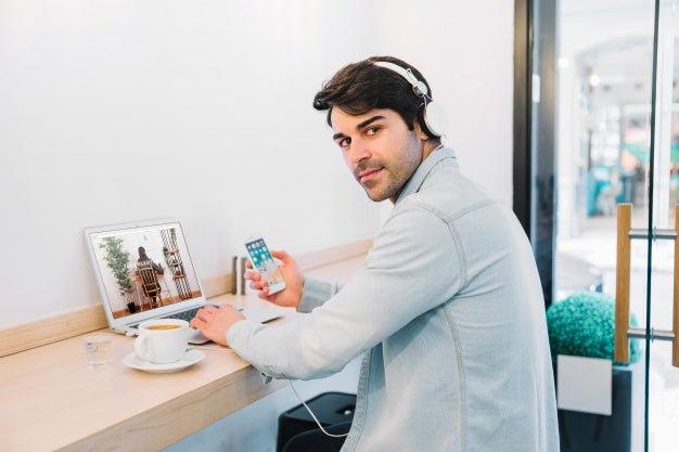 Free Laptop Mockup With Man Wearing Headphones Psd