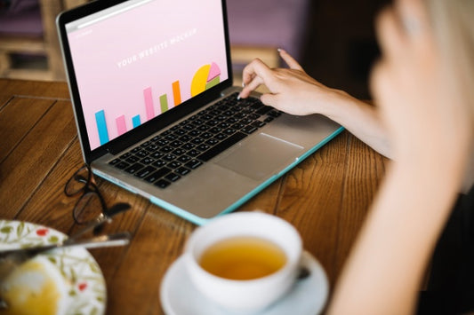 Free Laptop Mockup With Woman On Wooden Table Psd