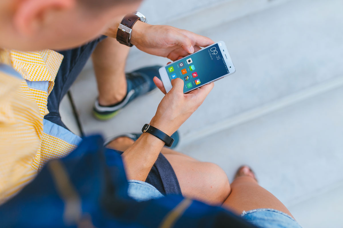 Free Man Holding Xiaomi Mi5 in His Hands PSD Mockups