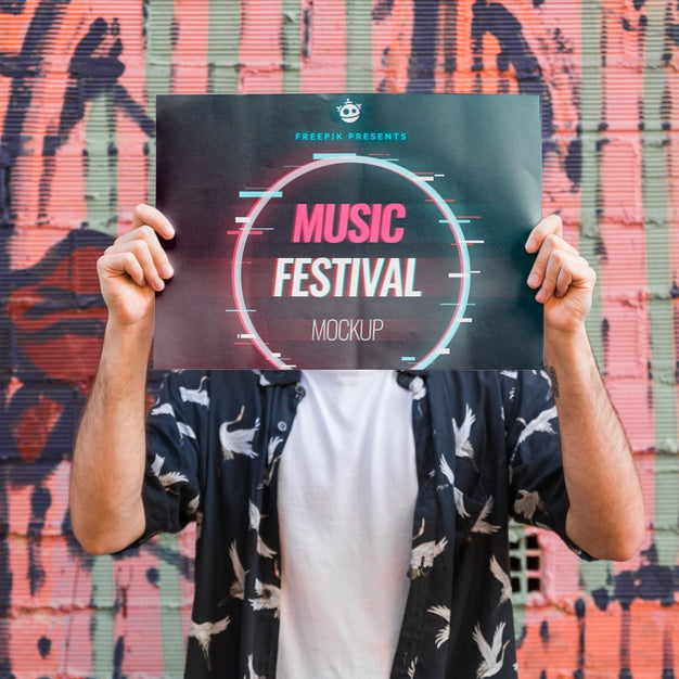 Free Man Presenting Poster Mockup In Front Of Graffiti Wall Psd