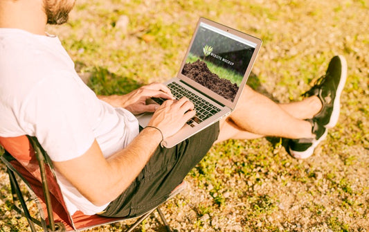 Free Man Using Laptop Mockup In Nature Psd