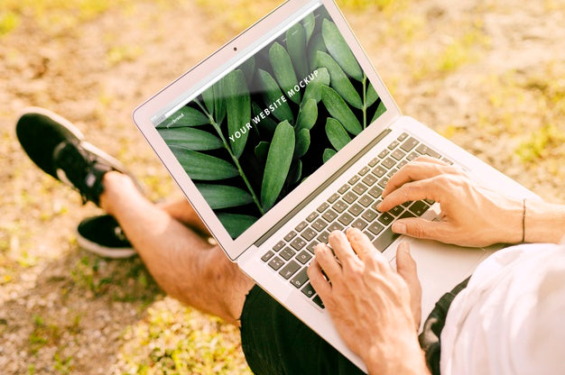 Free Man Using Laptop Mockup In Nature Psd