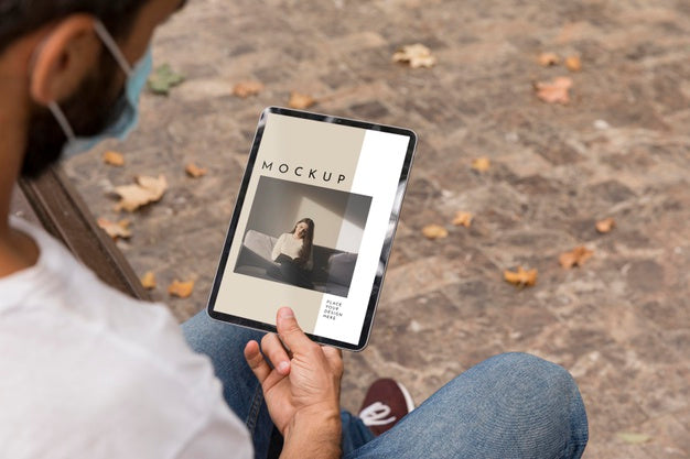 Free Man With Mask On Street Reading Book On Tablet Psd