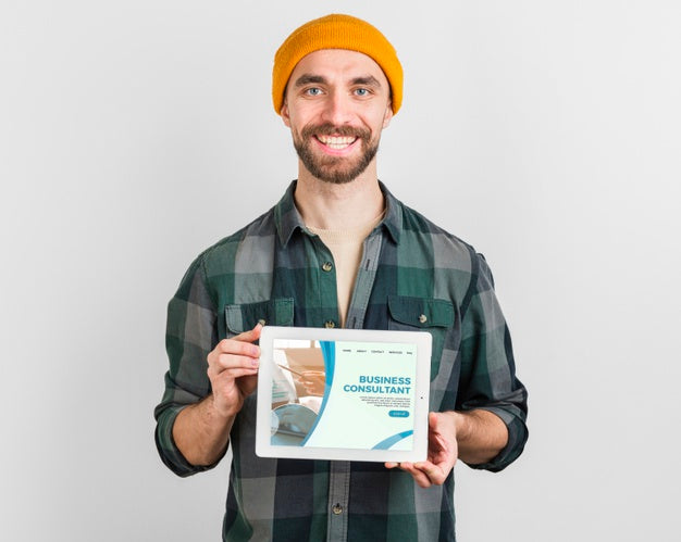 Free Man With Winter Hat Holding A Tablet With Business Landing Page Psd