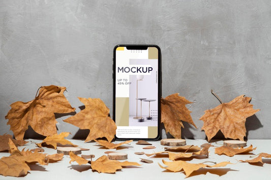 Free Mobile Phone Mockup Leaning On The Wall Surrounded By Leaves Psd