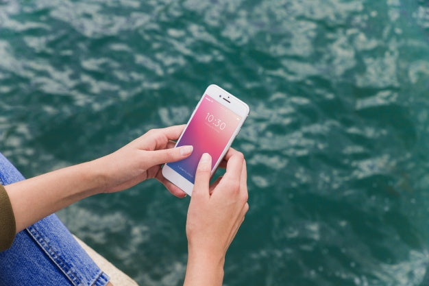 Free Person Using Smartphone Mockup On Sea Background Psd