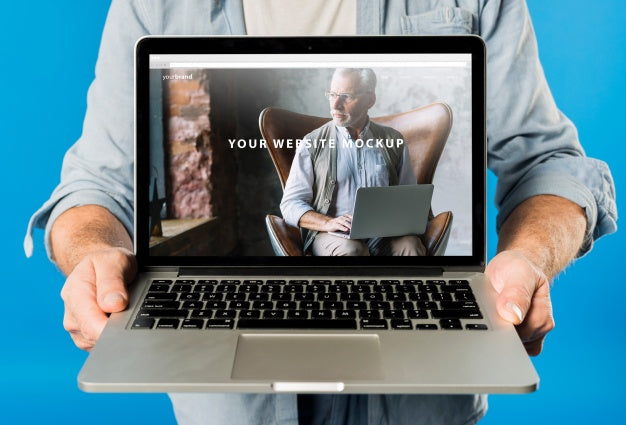 Free Senior Man Presenting Laptop Mockup Psd