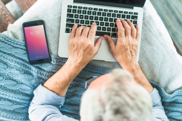 Free Smartphone Mockup For App Presentation With Man Using Laptop Psd