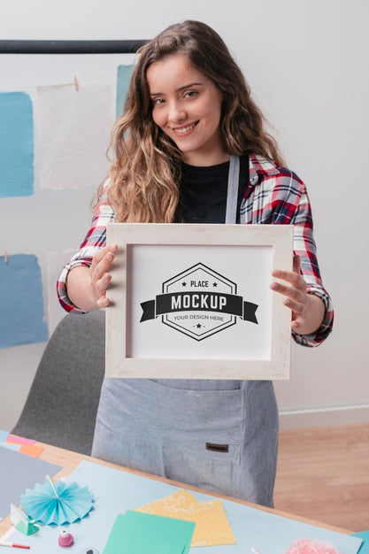 Free Smiley Female Artist Holding Mock-Up Frame Psd