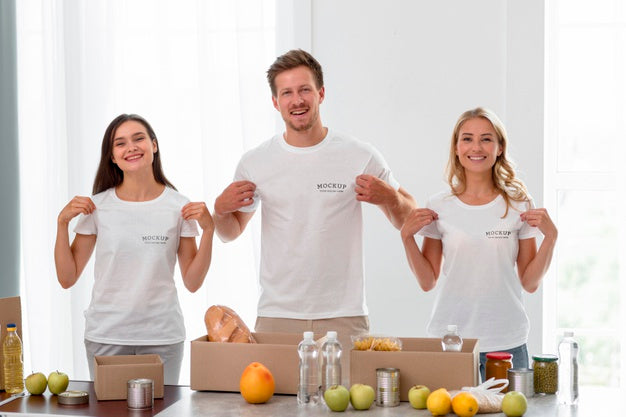 Free Smiley Volunteers Holding Their T-Shirts While Preparing Food For Donation Psd