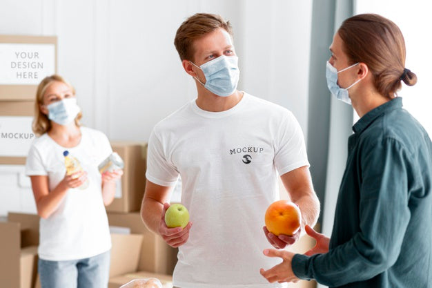 Free Volunteers With Medical Masks Handing Out Food To Man Psd