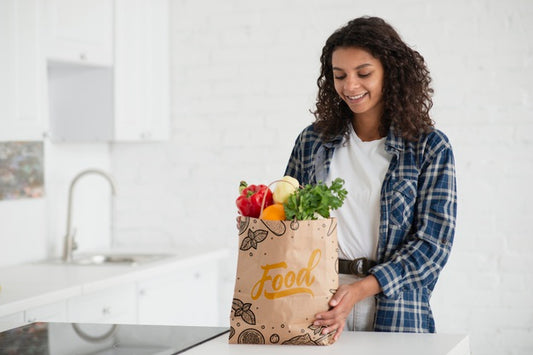 Free Woman In Kitchen With Bag Of Fresh Vegetables Psd