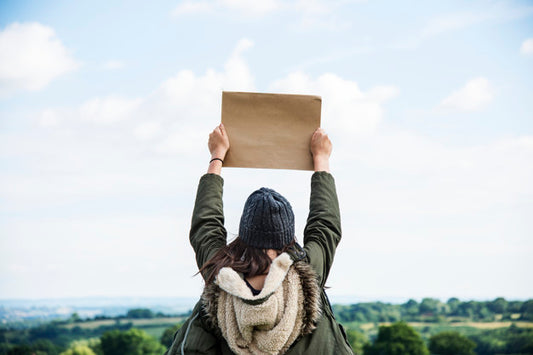 Free Woman In Nature Holding Cardboard Psd