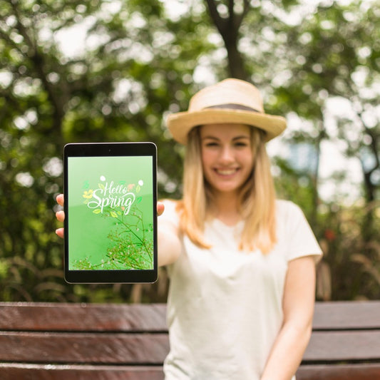 Free Woman Presenting Tablet Mockup In Nature Psd