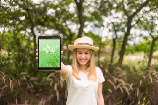 Free Woman Presenting Tablet Mockup In Nature Psd