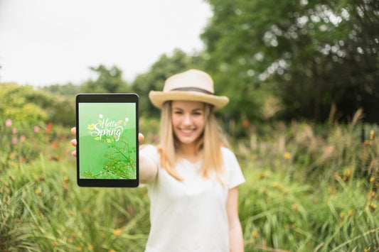 Free Woman Presenting Tablet Mockup In Nature Psd