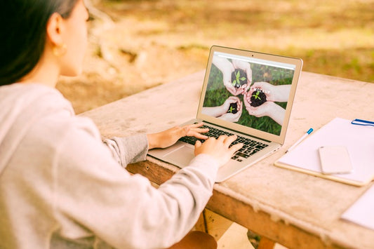 Free Woman Using Laptop Mockup In Nature Psd