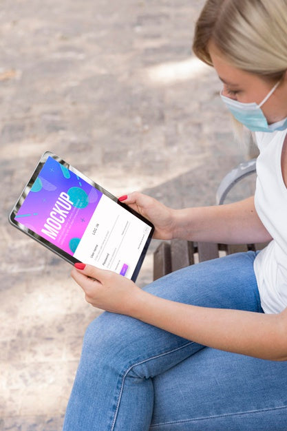 Free Woman Wearing Mask On Street Reading Book  On Tablet Psd