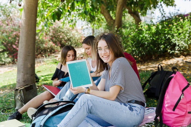 Free Women Looking At Tablet Mockup In Park Psd