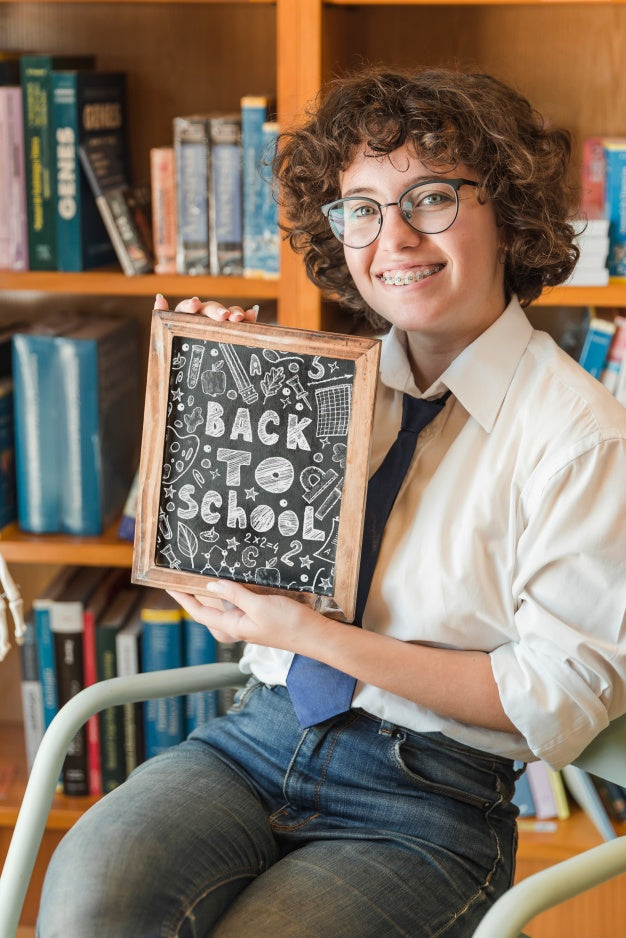 Free Young Woman Holding Slate Mockup In Library Psd